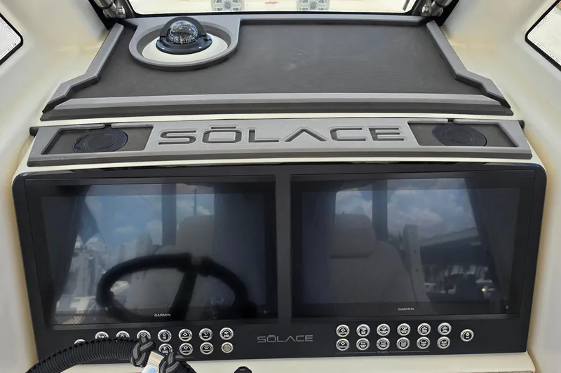 Slide: The Image of Dashboard of 2027 Solace 28HCS boat with dual screens and compass. - 16