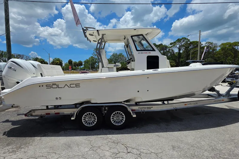 Slide: The Image of 2027 Solace 28HCS boat on trailer, side view, under clear blue sky. - 6
