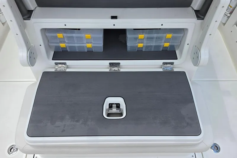 Slide: The Image of Storage compartment on a 2027 Solace 28HCS boat with organized tackle boxes. - 10