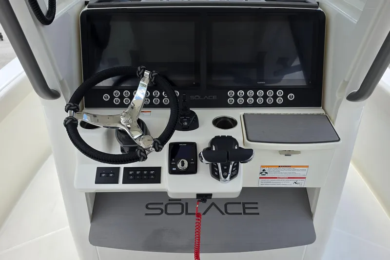 Slide: The Image of Control panel of 2027 Solace 28HCS boat with steering wheel and digital displays. - 14