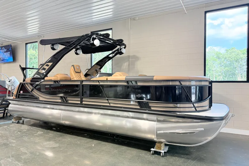 Slide: The Image of 2026 South Bay 525RS DC pontoon boat in showroom, featuring sleek design and modern amenities. - 1
