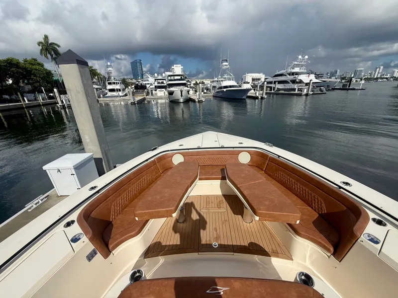 Slide: The Image of Scout 530 LXF 2024: Luxurious deck with cushioned seating in a marina. - 10