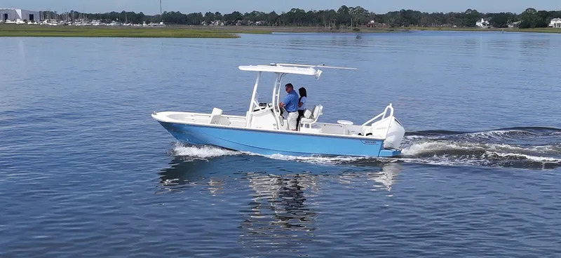 Slide: The Image of A blue and white 2027 Boston Whaler 210 Montauk on calm water with two people aboard. - 19