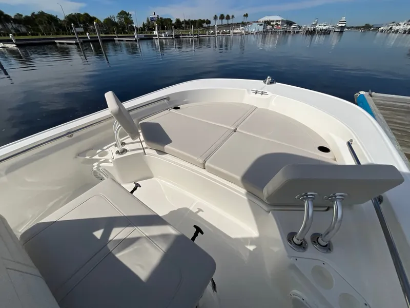 Slide: The Image of The image shows the deck of a 2027 Boston Whaler 210 Montauk. It features seating and is docked at a calm harbor. - 14