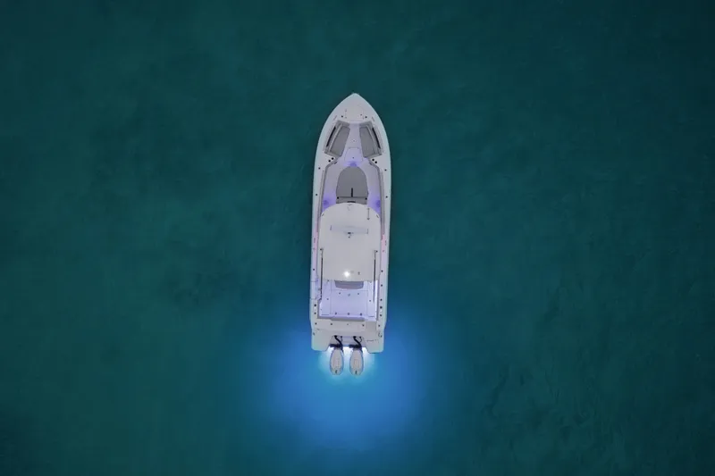 Slide: The Image of Aerial view of a Boston Whaler 330 Outrage on calm water with glowing underwater lights. - 4