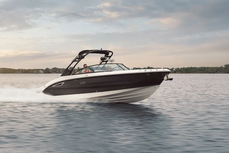 The Image of A 2026 Sea Ray SDX 270 boat speeds across calm water under a cloudy sky. - 0