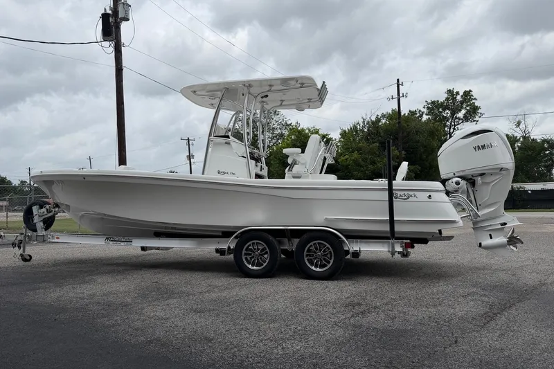 Slide: The Image of 2026 BlackJack 256 Coastal boat on trailer with Yamaha engine, parked outdoors. - 4