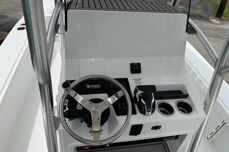 Slide: The Image of Steering console of 2026 BlackJack 256 Coastal boat with modern controls and cup holders. - 12