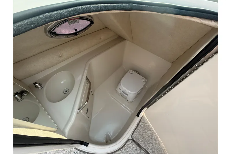 Slide: The Image of 2009 Sea Ray 240 Sundeck interior with compact marine toilet and sink. - 18