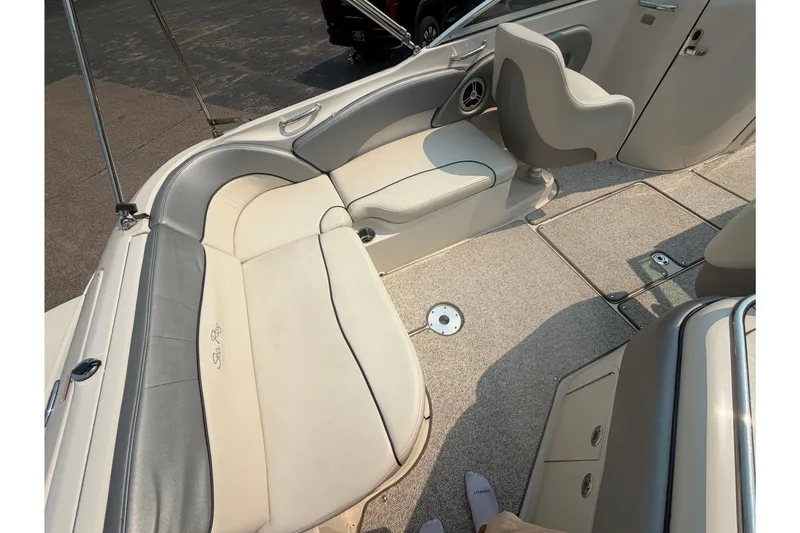 Slide: The Image of Interior of 2009 Sea Ray 240 Sundeck boat with beige seating and carpeted floor. - 16