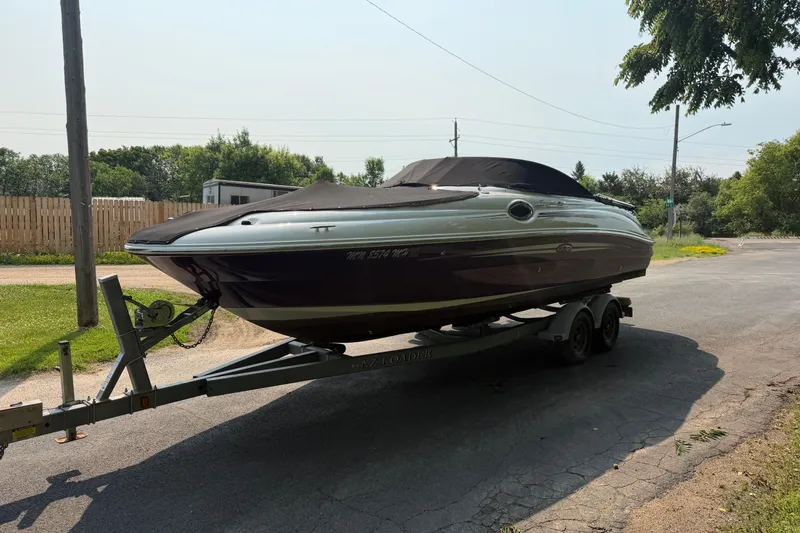 Slide: The Image of 2009 Sea Ray 240 Sundeck boat on trailer, parked outdoors on a sunny day. - 1