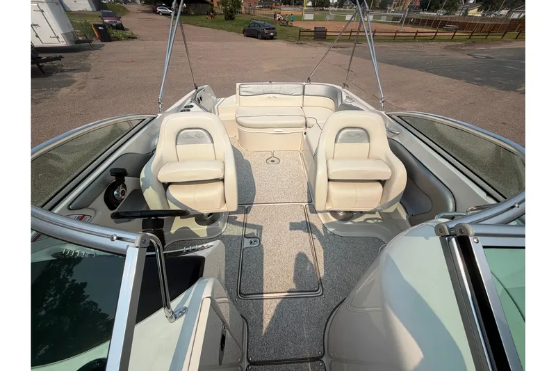 Slide: The Image of 2009 Sea Ray 240 Sundeck interior with beige seating and spacious layout. - 14