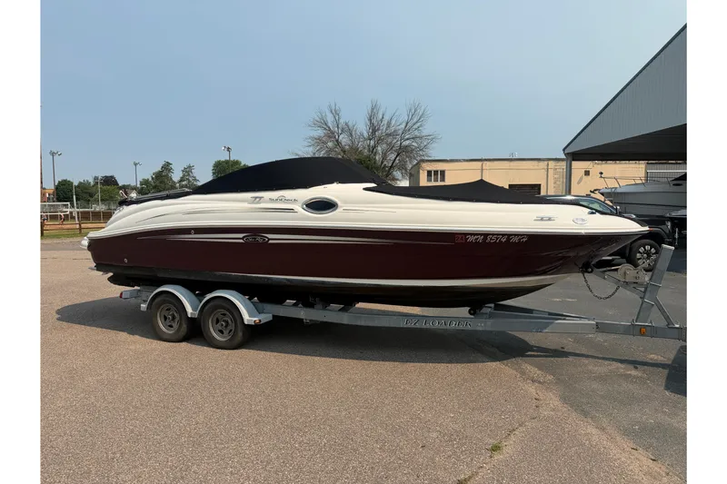 Slide: The Image of 2009 Sea Ray 240 Sundeck boat on trailer, parked outdoors. - 6