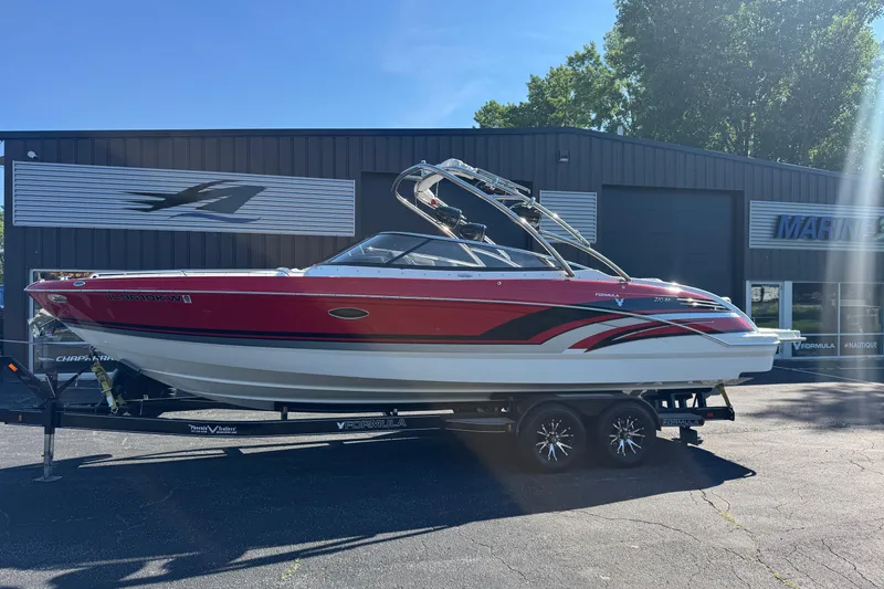 Slide: The Image of 2018 Formula 270 Bowrider boat on trailer, parked outside a marine dealership. - 4