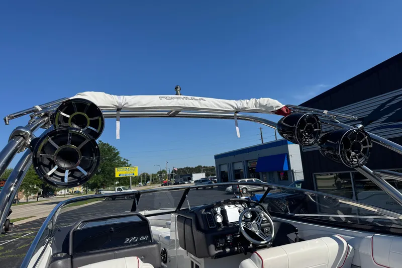 Slide: The Image of 2018 Formula 270 Bowrider boat with speakers and steering wheel, parked outdoors. - 16