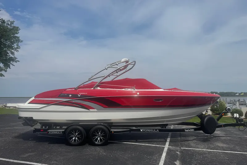 Slide: The Image of 2018 Formula 270 Bowrider boat in red, parked on a trailer by the waterfront. - 1