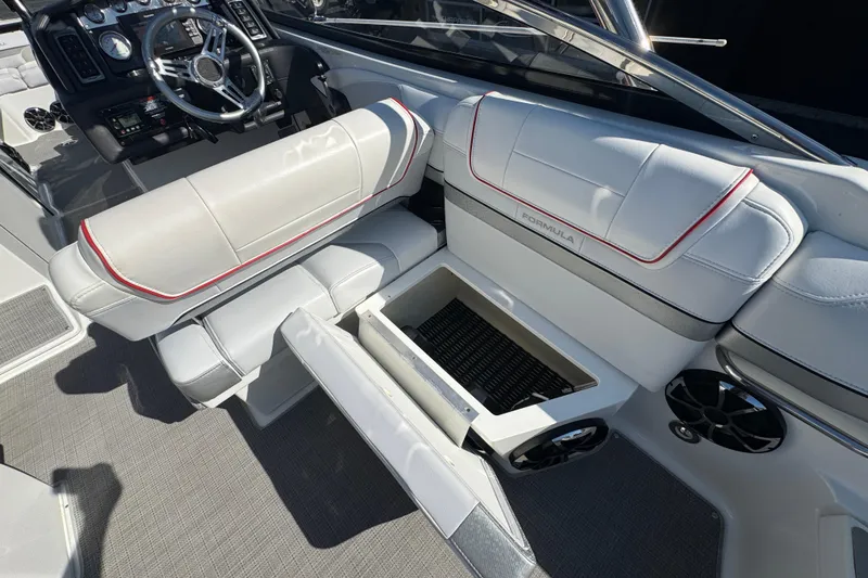 Slide: The Image of 2018 Formula 270 Bowrider interior with white seating, storage compartment, and steering wheel. - 10