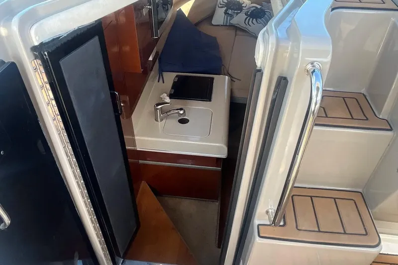 Slide: The Image of Interior view of 2010 Sea Ray Sundancer 260 boat with kitchenette and stairs. - 22