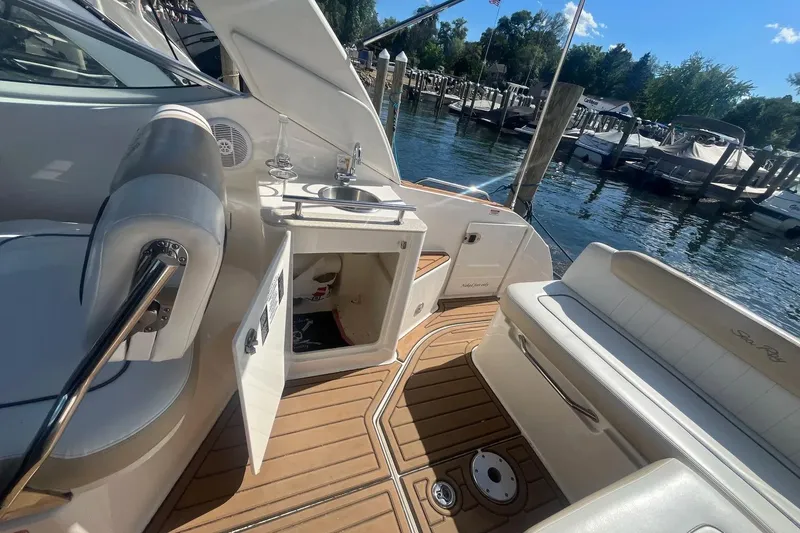 Slide: The Image of 2010 Sea Ray Sundancer 260 boat interior with seating, sink, and open storage compartment. - 14