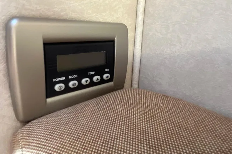 Slide: The Image of Control panel inside 2010 Sea Ray Sundancer 260 boat cabin, featuring power and temperature settings. - 31