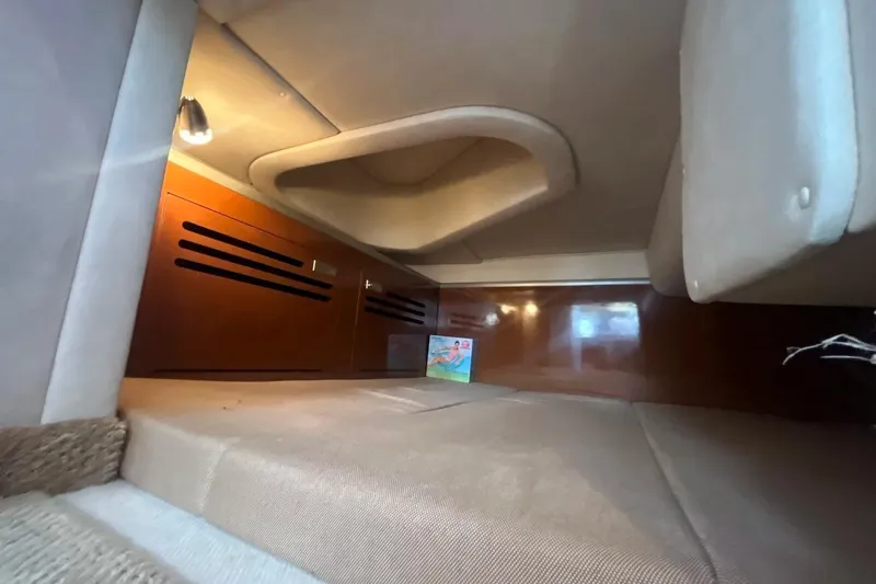 Slide: The Image of Interior cabin of 2010 Sea Ray Sundancer 260, featuring cozy sleeping area and wooden cabinetry. - 30