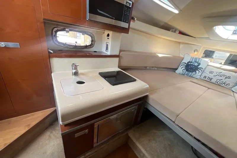 Slide: The Image of Interior of 2010 Sea Ray Sundancer 260 with kitchenette and cozy seating area. - 27