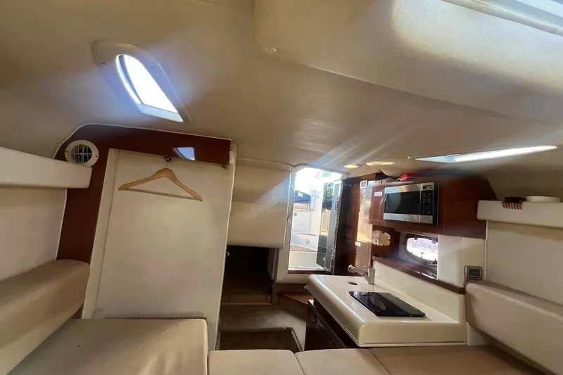 Slide: The Image of Interior of 2010 Sea Ray Sundancer 260 boat with kitchenette and seating area. - 28