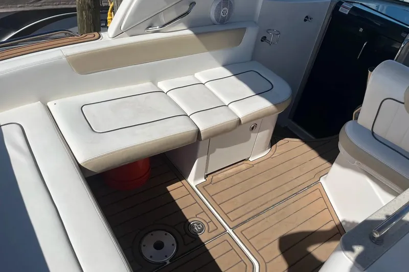 Slide: The Image of 2010 Sea Ray Sundancer 260 interior with white seating and teak flooring. - 9