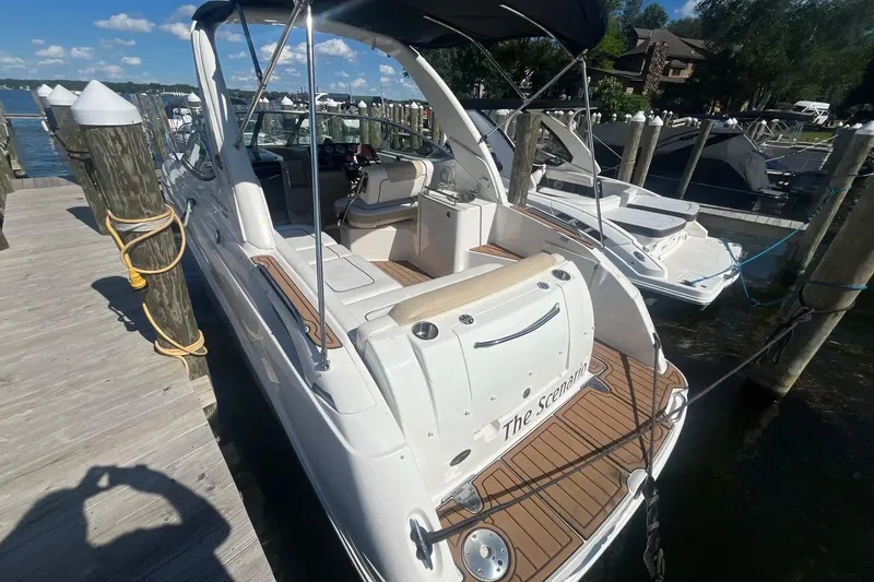 Slide: The Image of 2010 Sea Ray Sundancer 260 docked, featuring sleek design and spacious deck. - 6