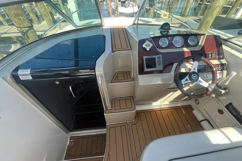 Slide: The Image of Cockpit of 2010 Sea Ray Sundancer 260 with wood accents and modern controls. - 19