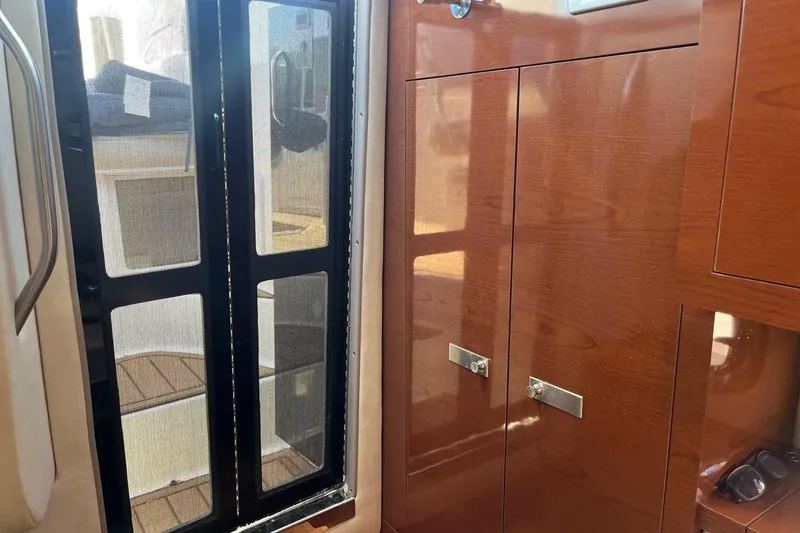 Slide: The Image of Interior view of 2010 Sea Ray Sundancer 260 with wooden cabinetry and screened door. - 25