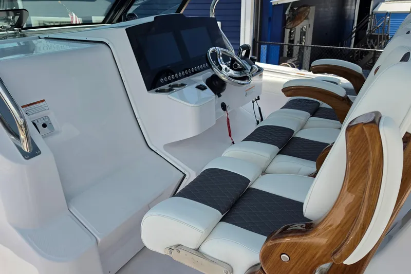 Slide: The Image of 2027 Bertram 39 CC boat cockpit with modern steering and cushioned seating. - 15