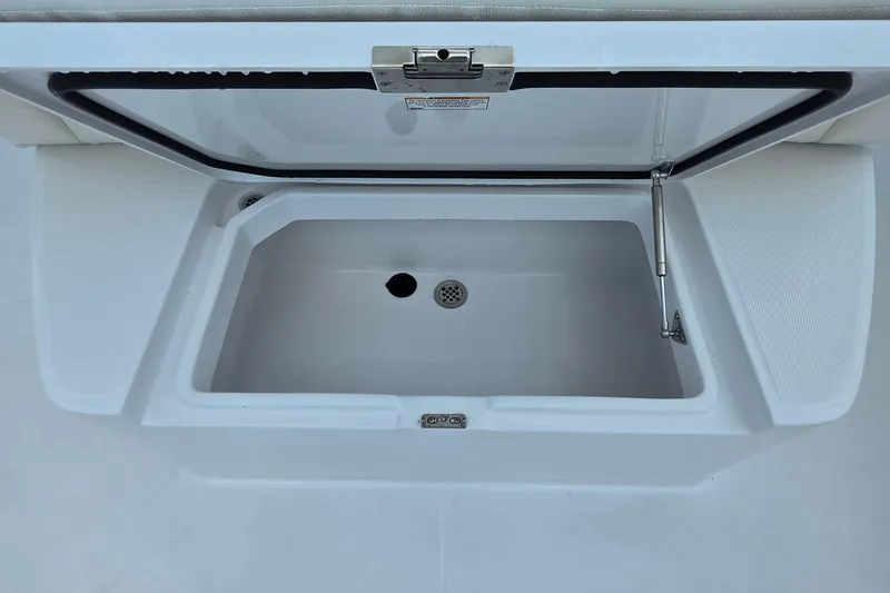 Slide: The Image of Open storage compartment on 2027 Bertram 39 CC boat, featuring a drain and secure latch. - 25