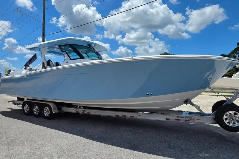 Slide: The Image of 2027 Bertram 39 CC boat on trailer under a clear blue sky. - 7