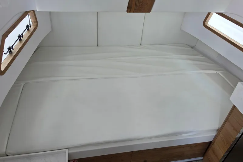 Slide: The Image of Interior cabin of 2027 Bertram 39 CC with white cushioned bed and wooden accents. - 36