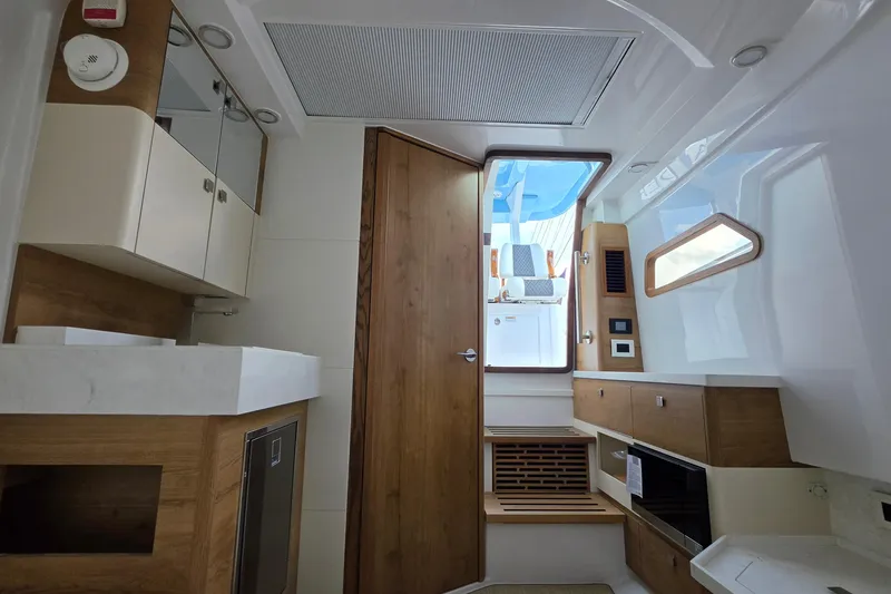 Slide: The Image of Interior of 2027 Bertram 39 CC boat featuring modern wood and white cabinetry. - 39