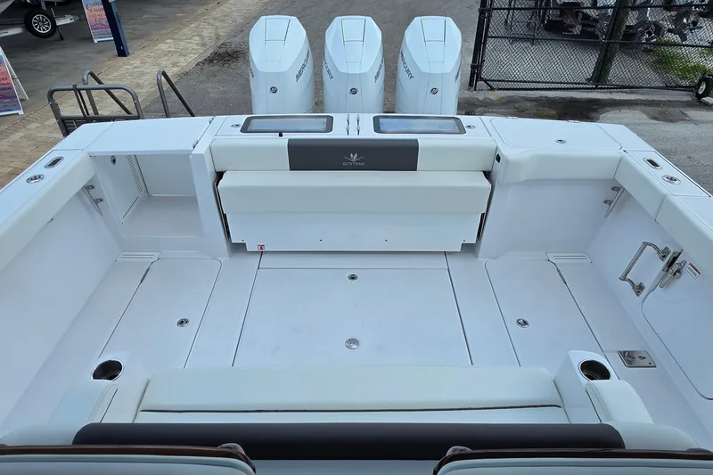 Slide: The Image of 2027 Bertram 39 CC boat deck with triple Mercury engines, spacious seating, and storage compartments. - 29
