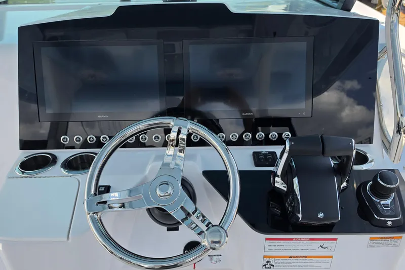 Slide: The Image of 2027 Bertram 39 CC helm with dual screens, steering wheel, and controls. - 13