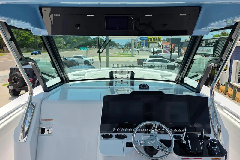 Slide: The Image of 2027 Bertram 39 CC boat cockpit with modern steering and navigation controls. - 14