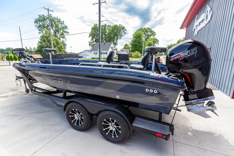 Slide: The Image of 2026 Recon 2085 T boat with Mercury Pro XS engine on a trailer, parked outdoors. - 7