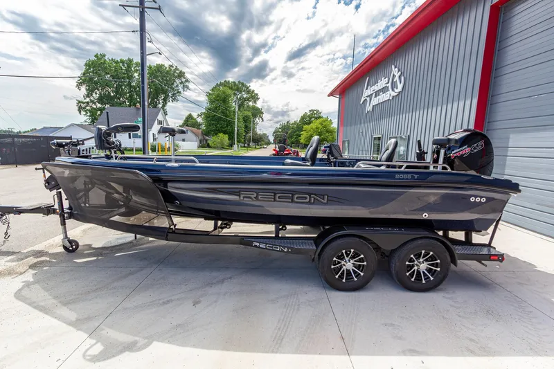 Slide: The Image of 2026 Recon 2085 T boat on trailer outside Lakeside Marina, under a cloudy sky. - 8