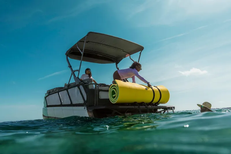 Slide: The Image of 2026 Sea-Doo Switch Cruise 21 on water, people enjoying sunny day, yellow float onboard. - 8