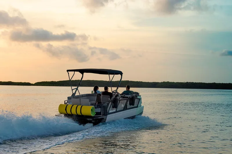 Slide: The Image of 2026 Sea-Doo Switch Cruise 21 pontoon boat cruising at sunset on calm waters. - 6