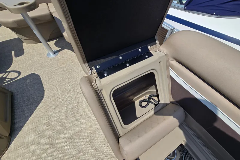 Slide: The Image of 2024 Bennington S22 boat interior storage compartment with beige seating and carpet. - 31