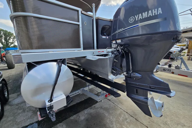 Slide: The Image of 2024 Bennington S22 pontoon boat with Yamaha outboard motor, docked on a trailer. - 8