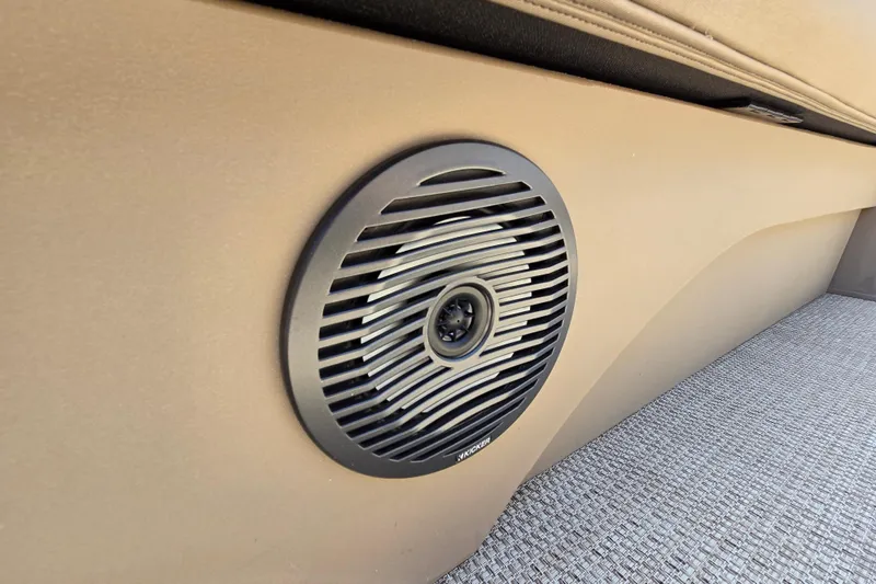 Slide: The Image of 2024 Bennington S22 boat interior speaker detail with beige upholstery and carpeted flooring. - 34