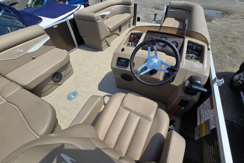 Slide: The Image of 2024 Bennington S22 boat interior with beige seating and modern steering console. - 16