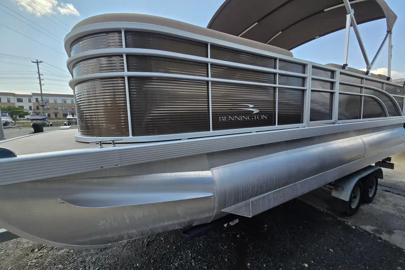 Slide: The Image of 2024 Bennington S22 pontoon boat on trailer, featuring sleek design and modern aesthetics. - 1