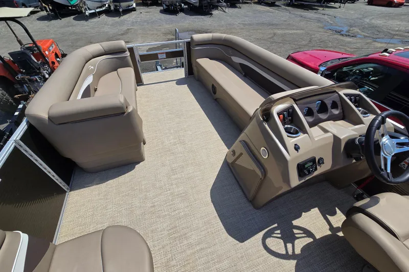 Slide: The Image of 2024 Bennington S22 pontoon boat interior with beige seating and steering console. - 14