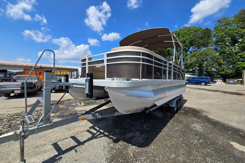Slide: The Image of 2024 Bennington S22 pontoon boat on trailer under clear blue sky. - 2